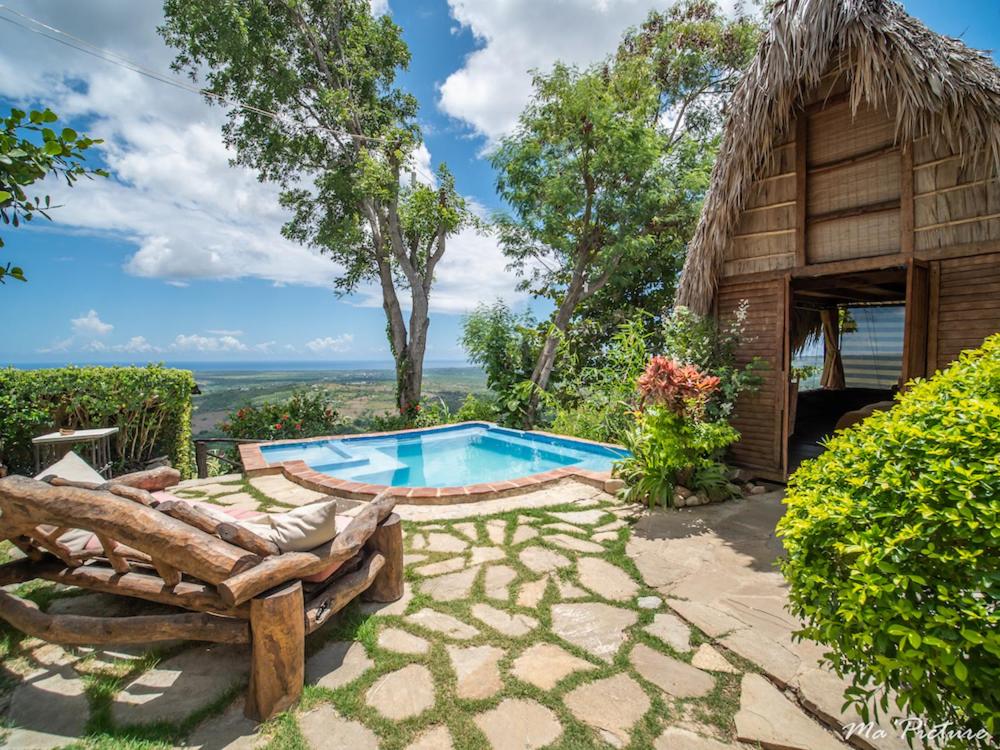 TubaguaEcolodge Tubagua Puerto Plata的一个带游泳池和小屋的度假村