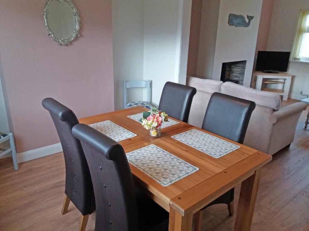 CrossmolinaLough Conn Holiday Home的木制用餐室配有桌椅和沙发