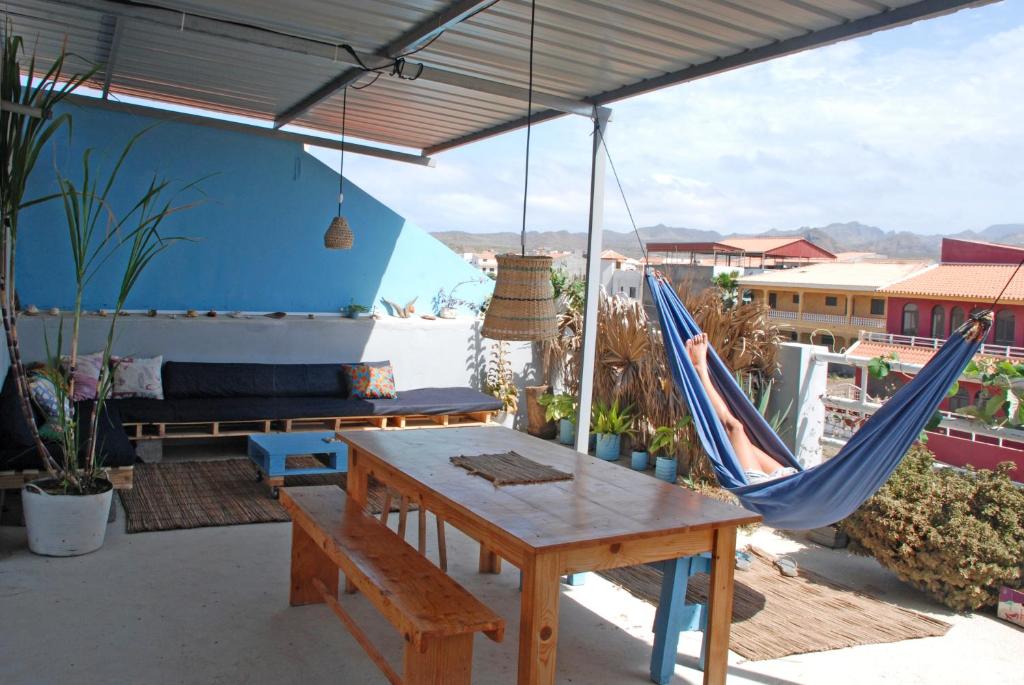 塔拉法尔Cloud7 Beach Hostel的天井配有吊床、桌子和长凳