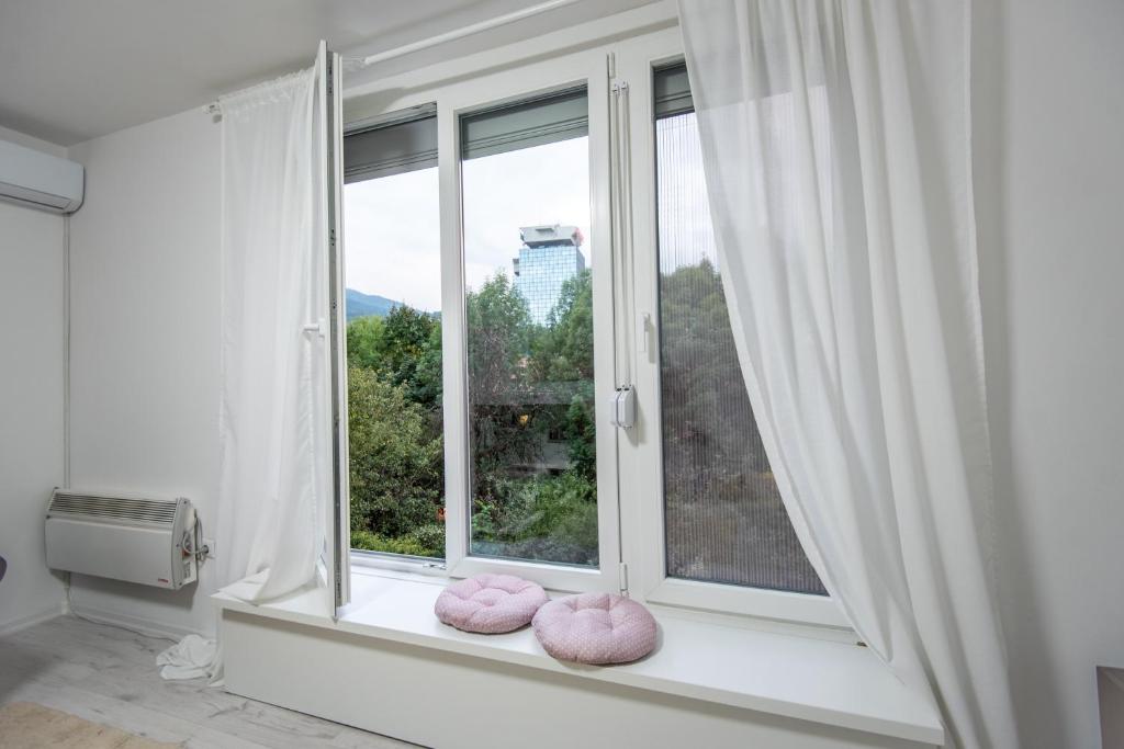 萨拉热窝Apartment Kalemova的窗户窗边的窗户,上面有粉红色枕头
