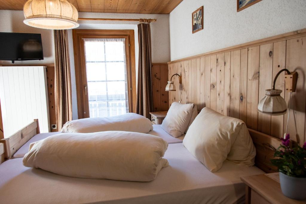 圣玛利亚瓦尔姆斯塔尔Alpina B&B Apartments的客房设有两张带枕头的床。