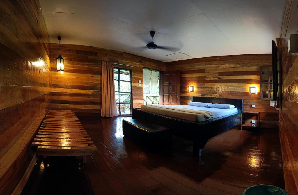 比利特最后疆域精品度假山林小屋的一间卧室配有一张床和长凳