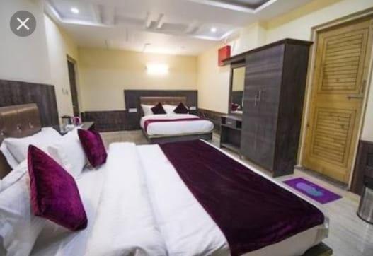 达兰萨拉Vella Marina Group of Hotels的一间大卧室,配有两张带紫色枕头的床