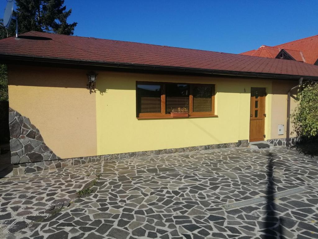 波普拉德Útulný Domček Privat Bedrich的黄色的房子,设有窗户和石头地板