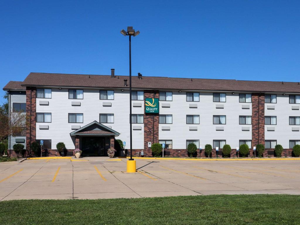 布卢明顿Quality Inn & Suites Bloomington I-55 and I-74的一座白色的大建筑,前面有黄色消防栓