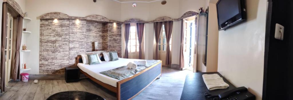 瓦拉纳西湿婆恒河景观旅馆的一间卧室设有一张大床和砖墙