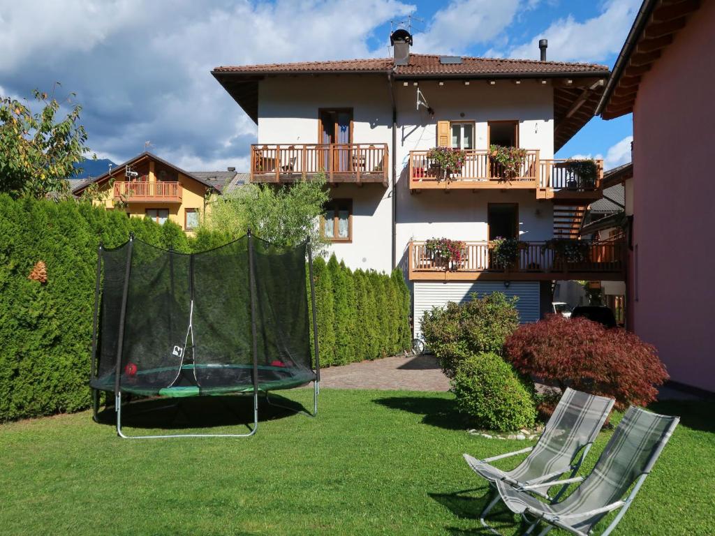 卡尔多纳佐Apartment Schmid by Interhome的一个带两把草坪椅和蹦床的院子