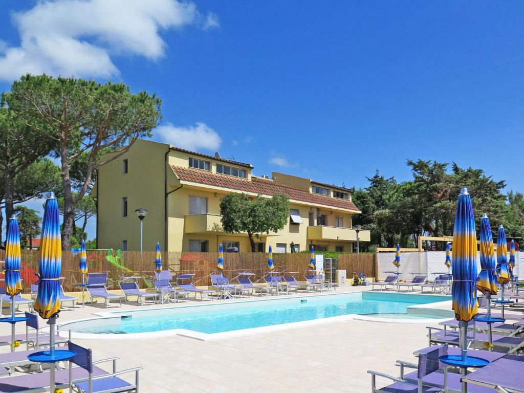 切齐纳码头Apartment Riviera 1 by Interhome的一个带蓝色和黄色遮阳伞及椅子的游泳池