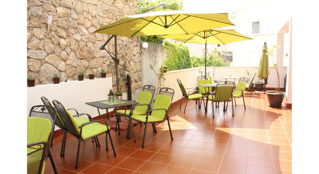 察夫塔特Guest House Sol的一个带桌椅和黄色遮阳伞的庭院