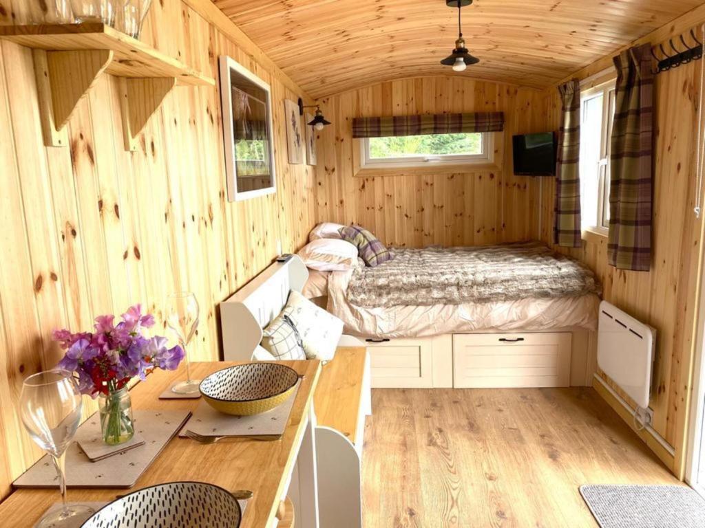 珀斯Remarkable Shepherds Hut in a Beautiful Location的一间小房子里带床和桌子的房间