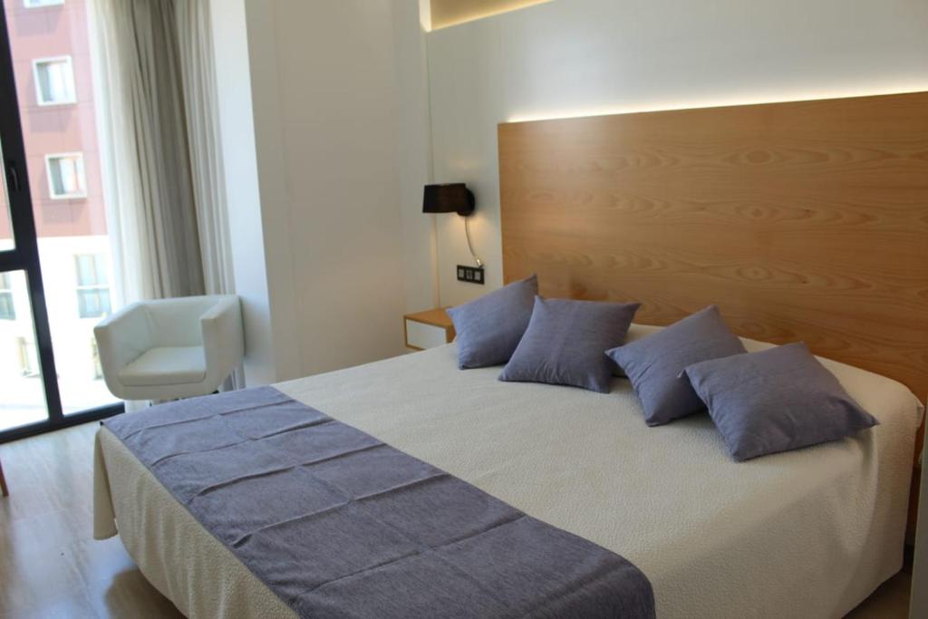 格罗韦Hotel La Noyesa *** Superior的一间卧室配有一张带蓝色枕头的大床