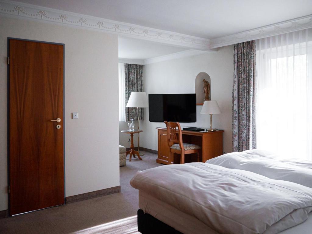 巴特温嫩贝格帕克酒店的一间卧室配有一张床和一台平面电视