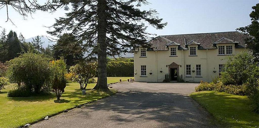 凯里肯Isle of Skye Guest House的一座大型白色房子,有树和车道