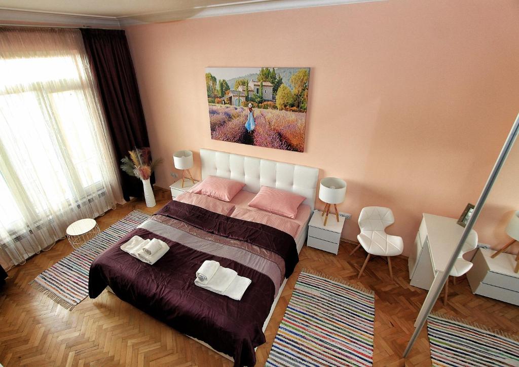 索非亚Colorful apartment的卧室配有一张床,墙上挂有绘画作品