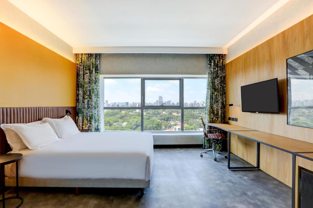 圣保罗Hilton Garden Inn Rebouças的酒店客房,配有床和电视