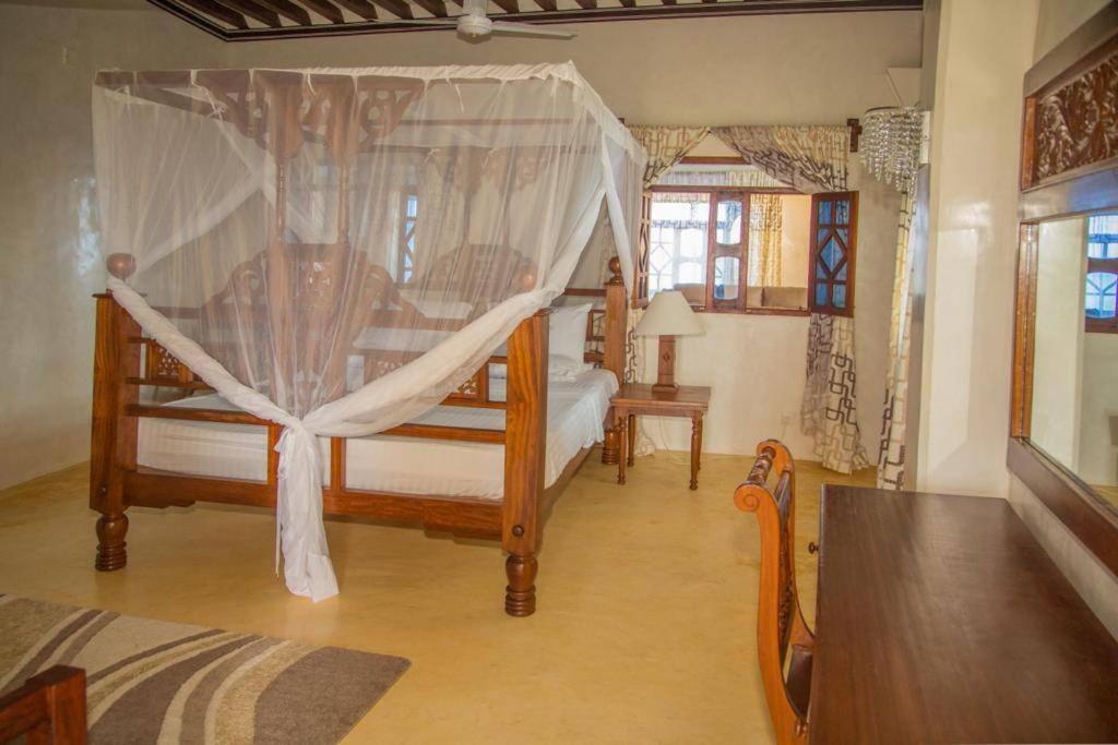 拉穆MANDA ISLAND Private Villa的一间卧室配有两张带天蓬的床