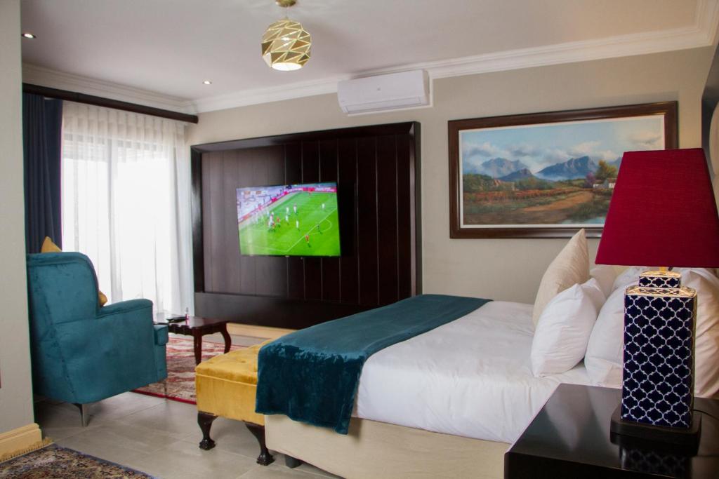 波罗瓜尼Sasavona Boutique Hotel的一间卧室配有一张床,墙上配有电视