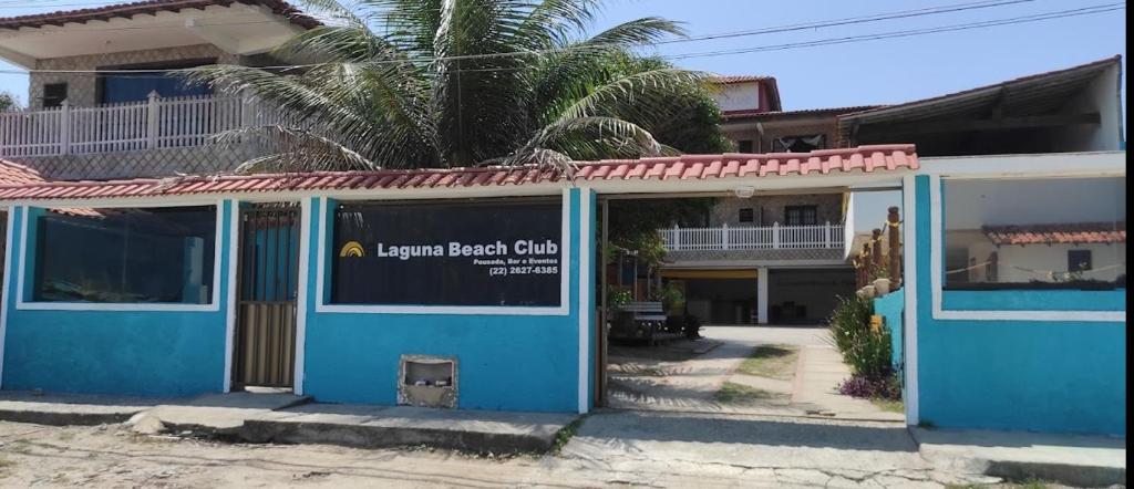 圣佩德罗-达阿尔德亚Pousada Laguna Beach Club的蓝色的建筑,前面有标志