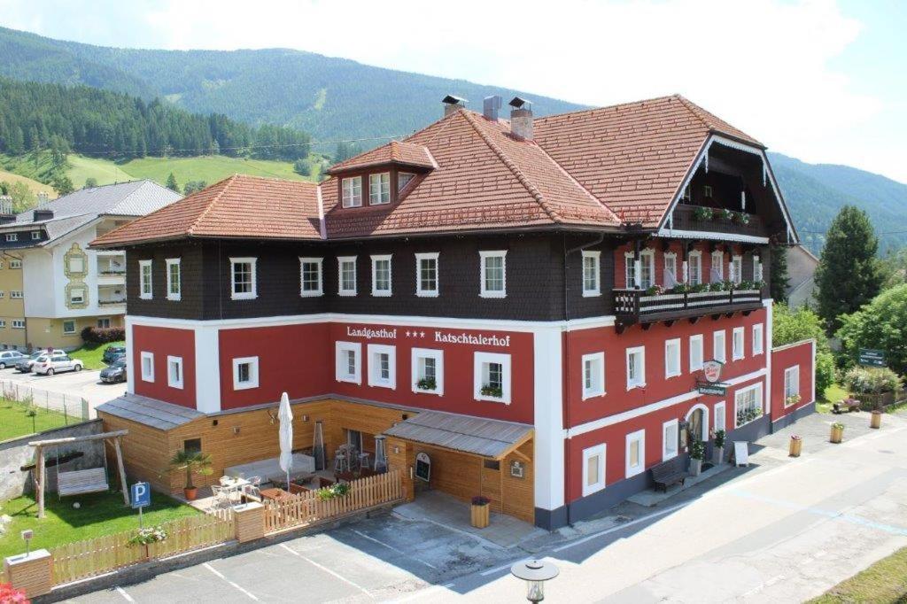 伦韦格Hotel-Landgasthof Katschtalerhof的棕色屋顶的大型红色建筑