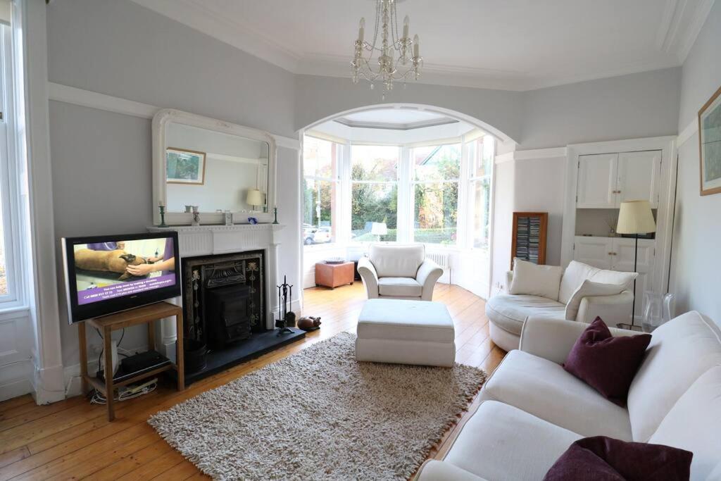 格拉斯哥Two Bed Holiday Home in Glasgow的客厅配有白色家具和平面电视