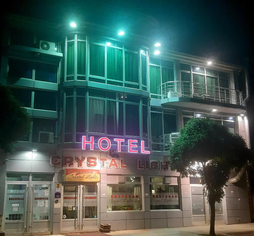皮罗特HOTEL Crystal Lights的一家晚上在它前面有 ⁇ 虹灯标志的酒店