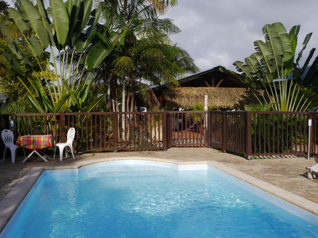 Matoury马尔莫特酒店的一个带围栏的院子内的游泳池