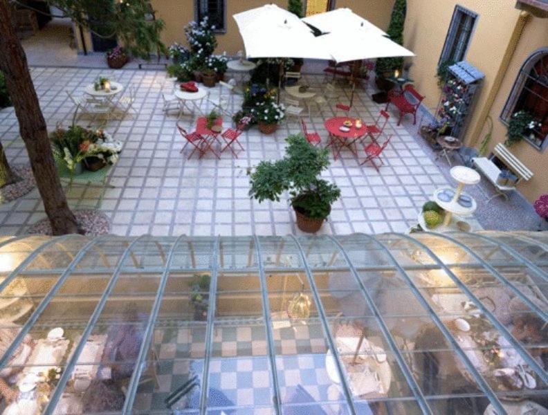 托尔托纳Albergo Residence Perosi的一个带桌椅的庭院模型