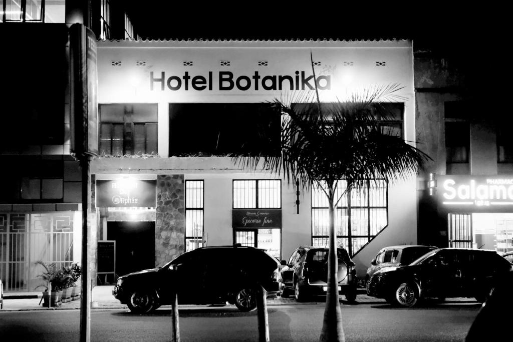 布琼布拉Botanika Hotel的在酒店门前停车的旅馆