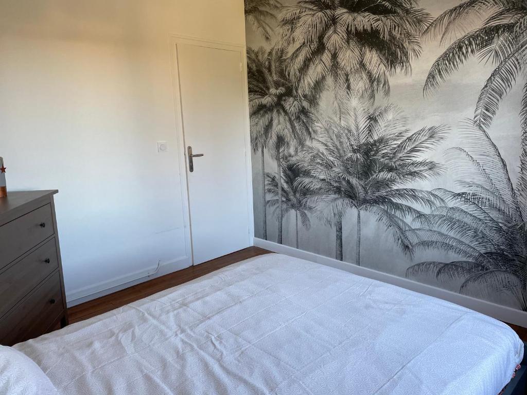 洛特河畔的维伦纽夫Maison chaleureuse的一间卧室配有一张棕榈树壁画床