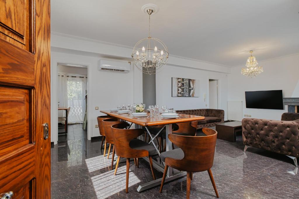 阿哈奈Filippos Acharnes Elegance的用餐室以及带桌椅的起居室。