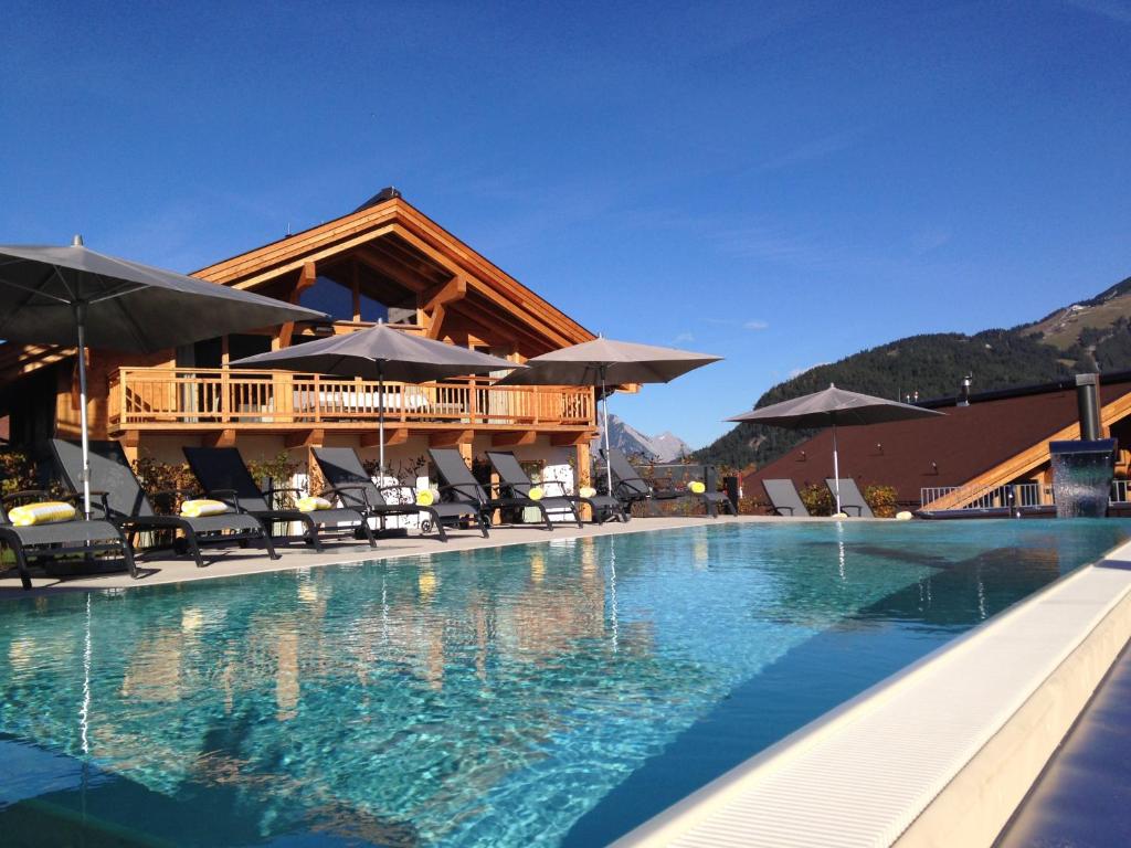 蒂罗尔-泽费尔德Mountains Hotel的一个带游泳池和房子的度假胜地