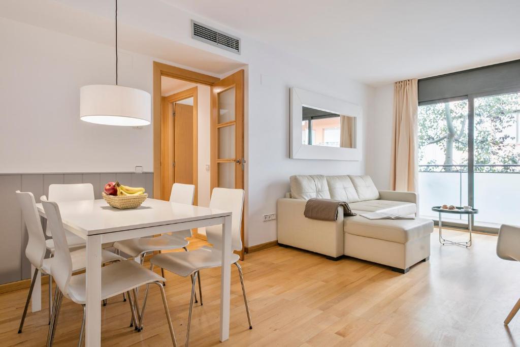巴塞罗那Inside Barcelona Apartments Princep的用餐室以及带白色桌椅的起居室。
