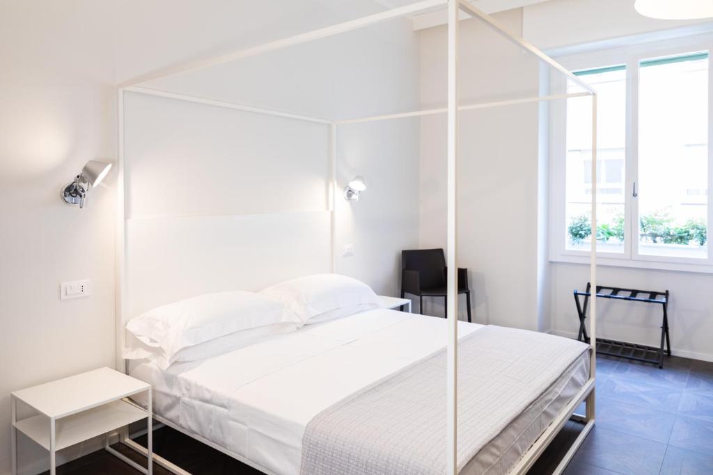 罗马flaminia354 - Alloggio Turistico的白色卧室设有天蓬床和窗户