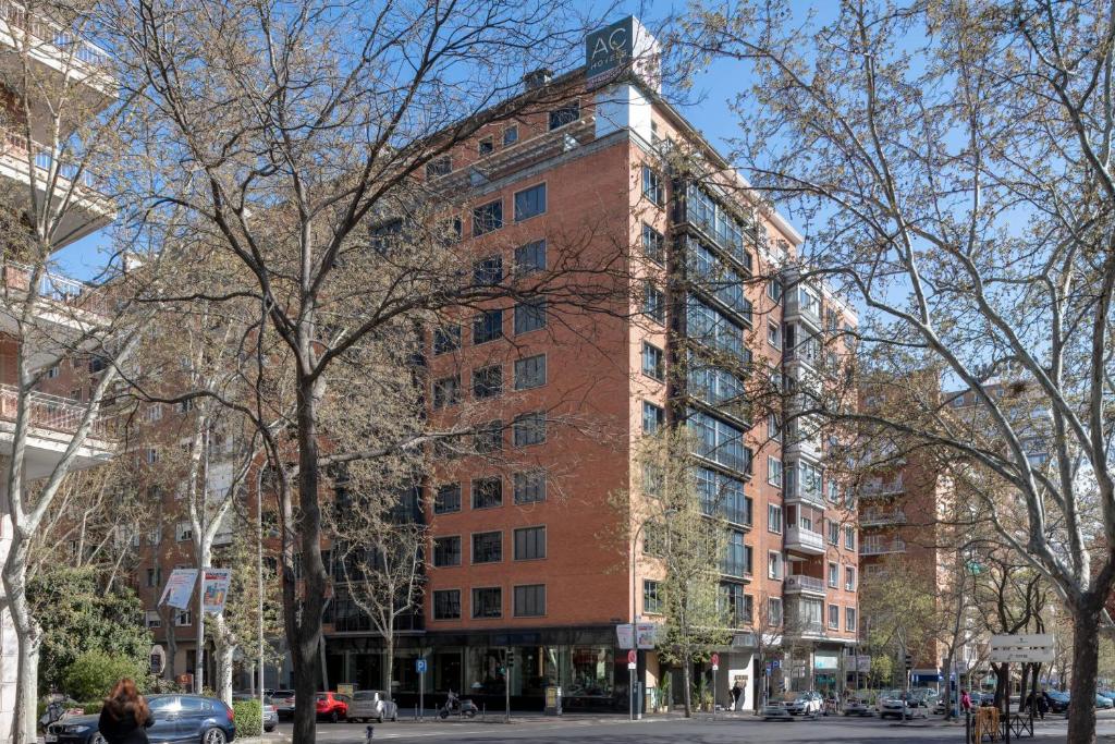 马德里艾塔纳万豪AC酒店的城市街道上一座高大的红砖建筑