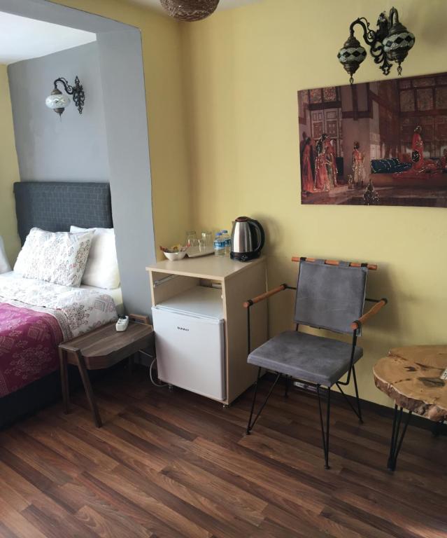 伊斯坦布尔Marmara House&Apartments的一间卧室配有一张床、一把椅子和一张桌子