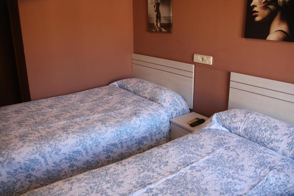 MilagroHOSTAL BURGALES的一间客房内配有两张床的房间