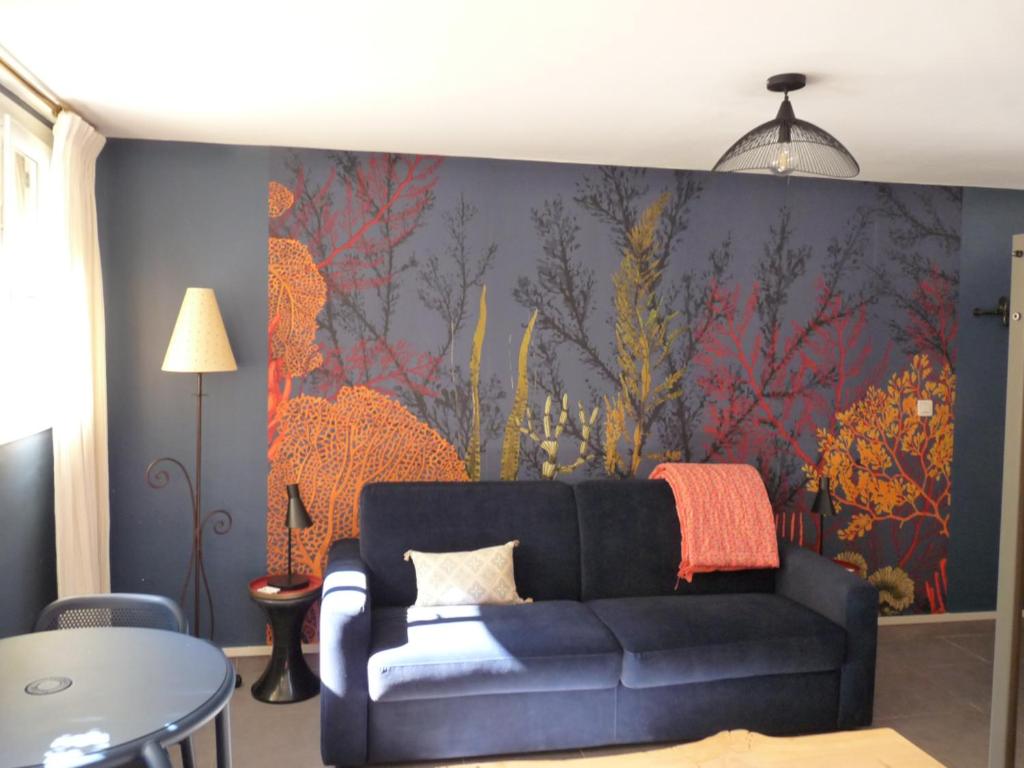 马赛LE LOGIS DU PALAIS的客厅配有沙发和墙上的绘画