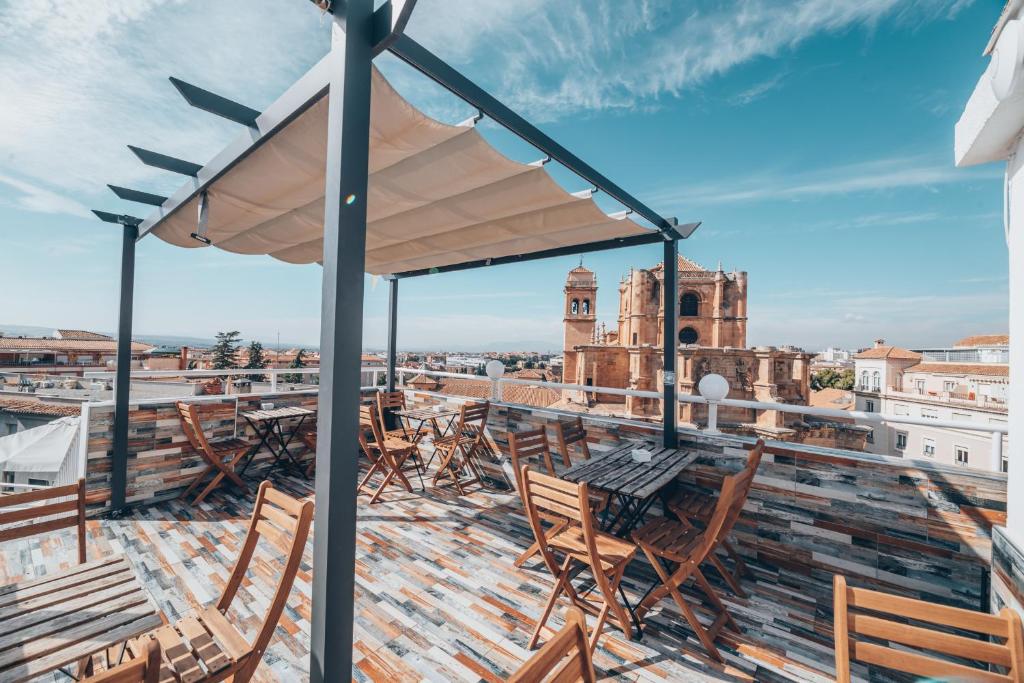 格拉纳达Hotel Monasterio Granada - Adults Only的从带桌椅的建筑屋顶上可欣赏到风景