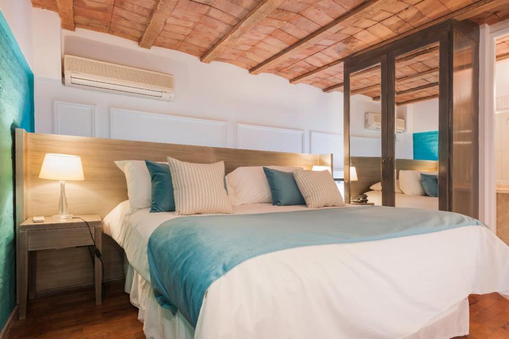 布宜诺斯艾利斯San Telmo Suites的一间卧室配有一张带蓝白色枕头的大床