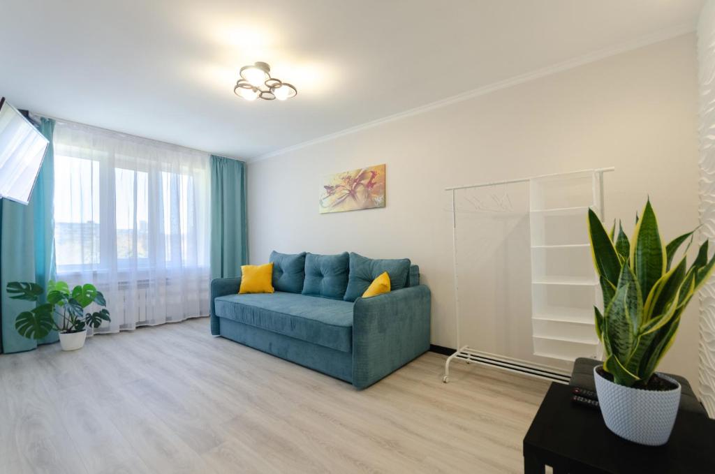 基辅ARTAL Apartment on Obolonskaya Square 1的客厅设有蓝色的沙发和窗户。