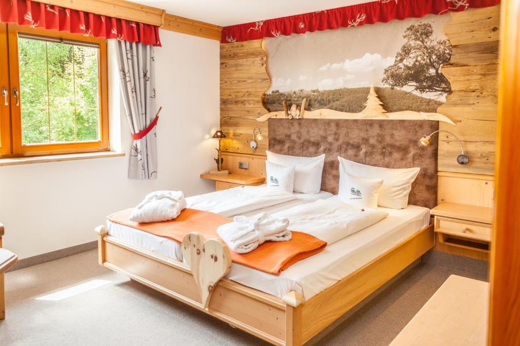 贝尔费德科勒胡特 - 富森博酒店及餐厅的一间卧室配有一张大床和木制床头板