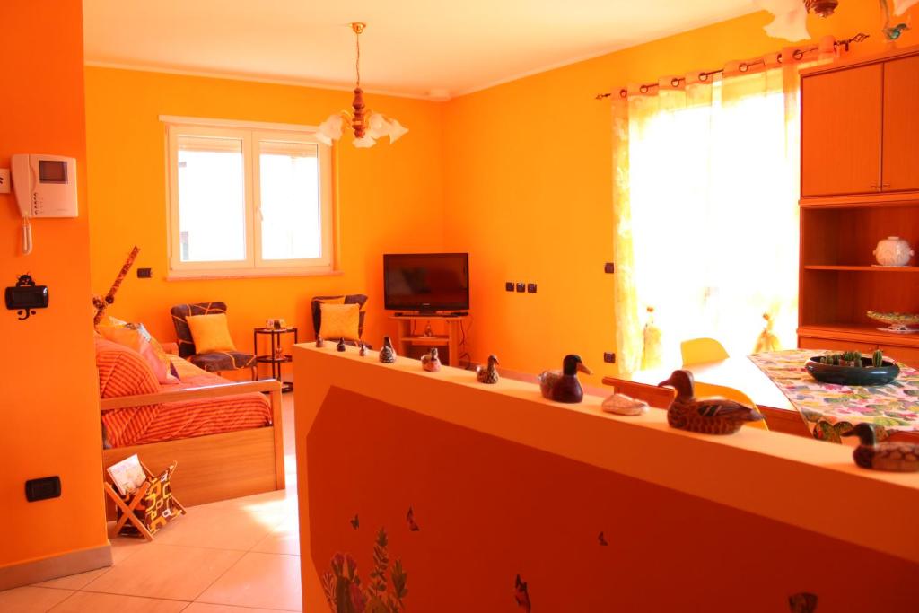 阿罗纳Il Mondo di Dedo的带橙色墙壁的厨房和客厅