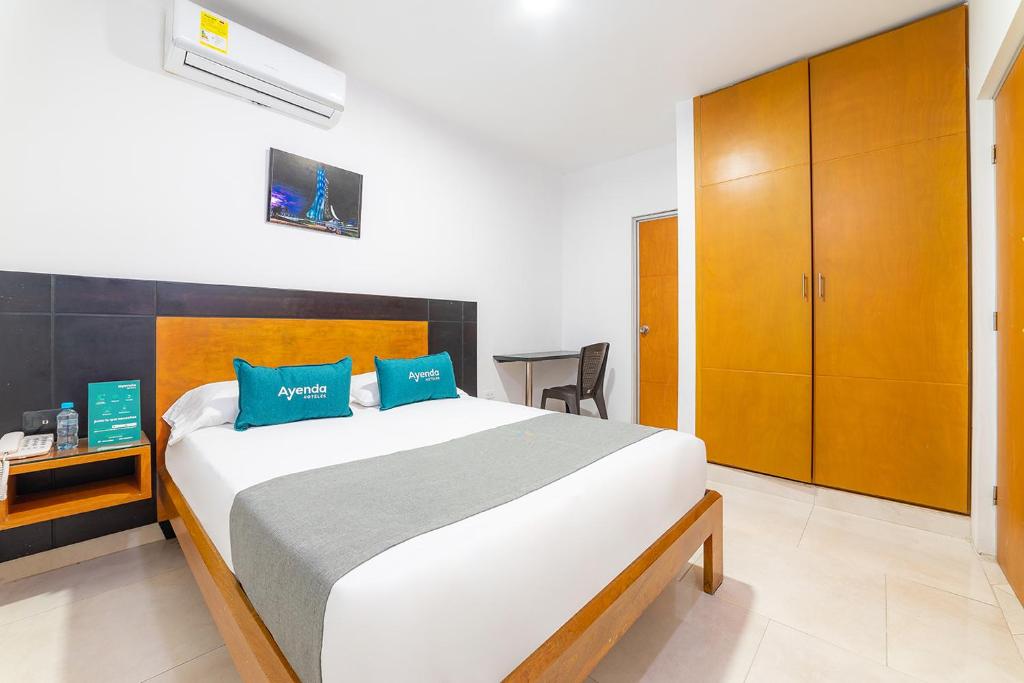 库库塔Ayenda Zhena的一间卧室配有一张带蓝色枕头的大床