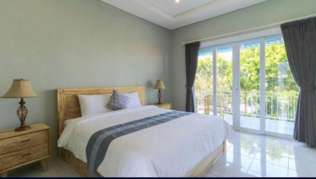 坎古Anyar Guesthouse Canggu的一间卧室设有一张床和一个大窗户