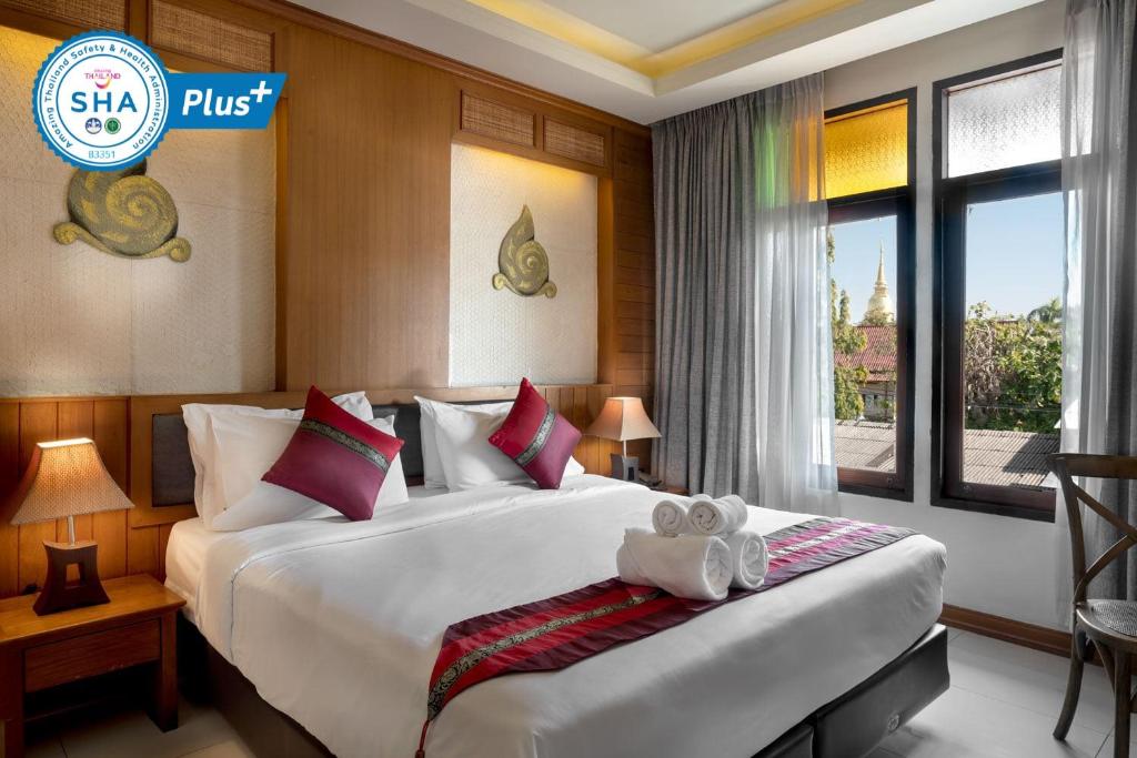 清迈Lee Chiang Hotel的酒店客房设有两张床和窗户。