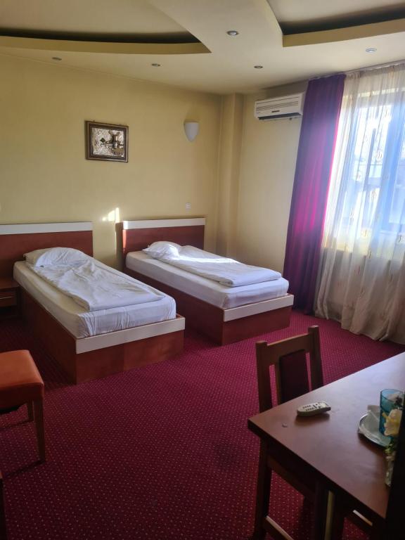 普洛耶什蒂Bistro 29的酒店客房设有两张床和一张桌子。