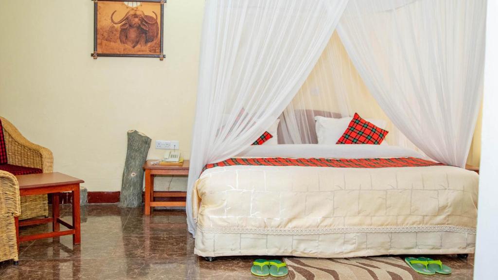 阿鲁沙Karibu Heritage House的一间卧室配有一张带天蓬的床