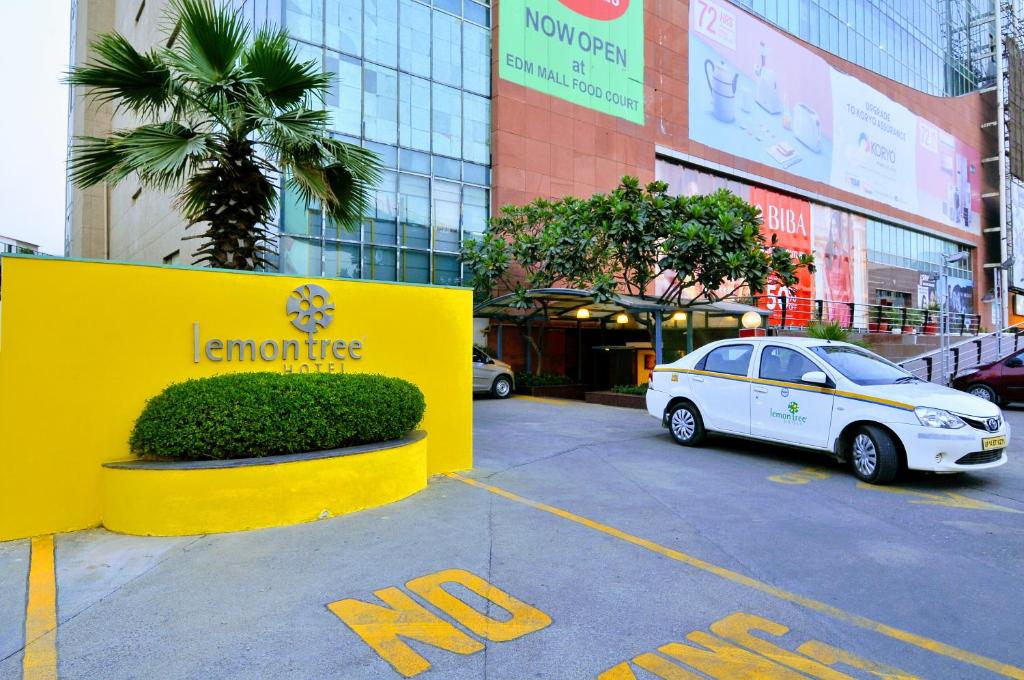 加济阿巴德考夏姆比东德里购物商场柠檬树酒店的停在大楼前停车场的汽车