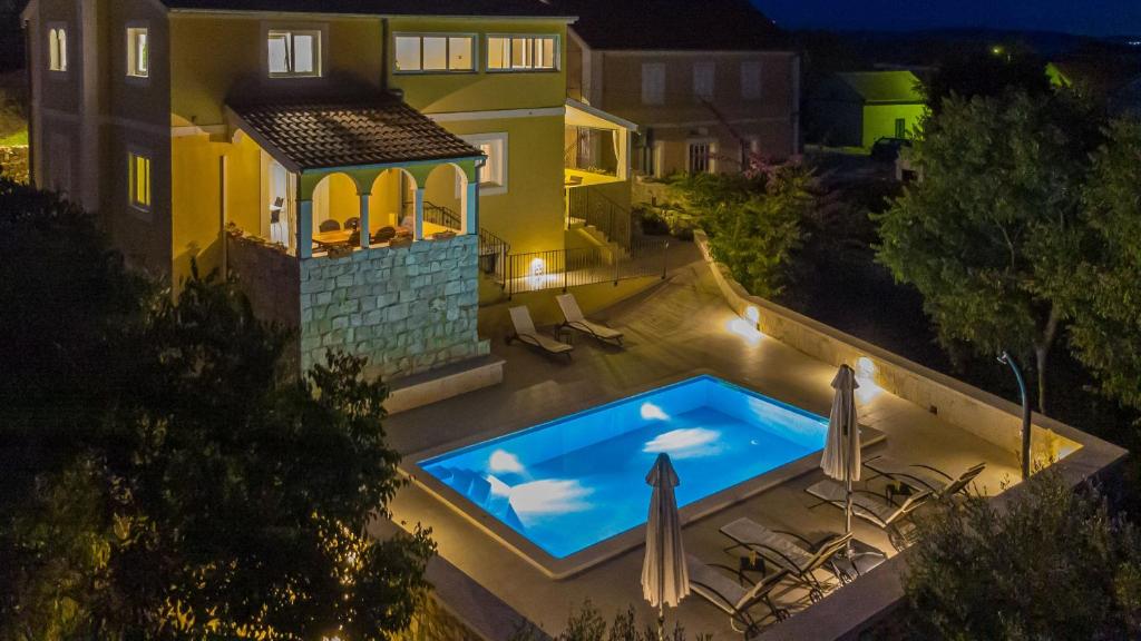 萨利Villa Sali的夜间房子后院的游泳池