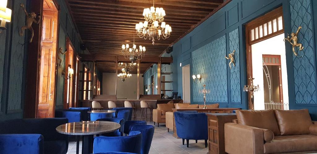 底拉斯卡拉Hotel San Francisco Tlaxcala的餐厅拥有蓝色的墙壁和桌椅